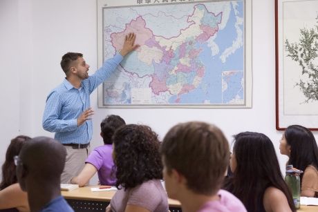 Teacher pointing at map in class